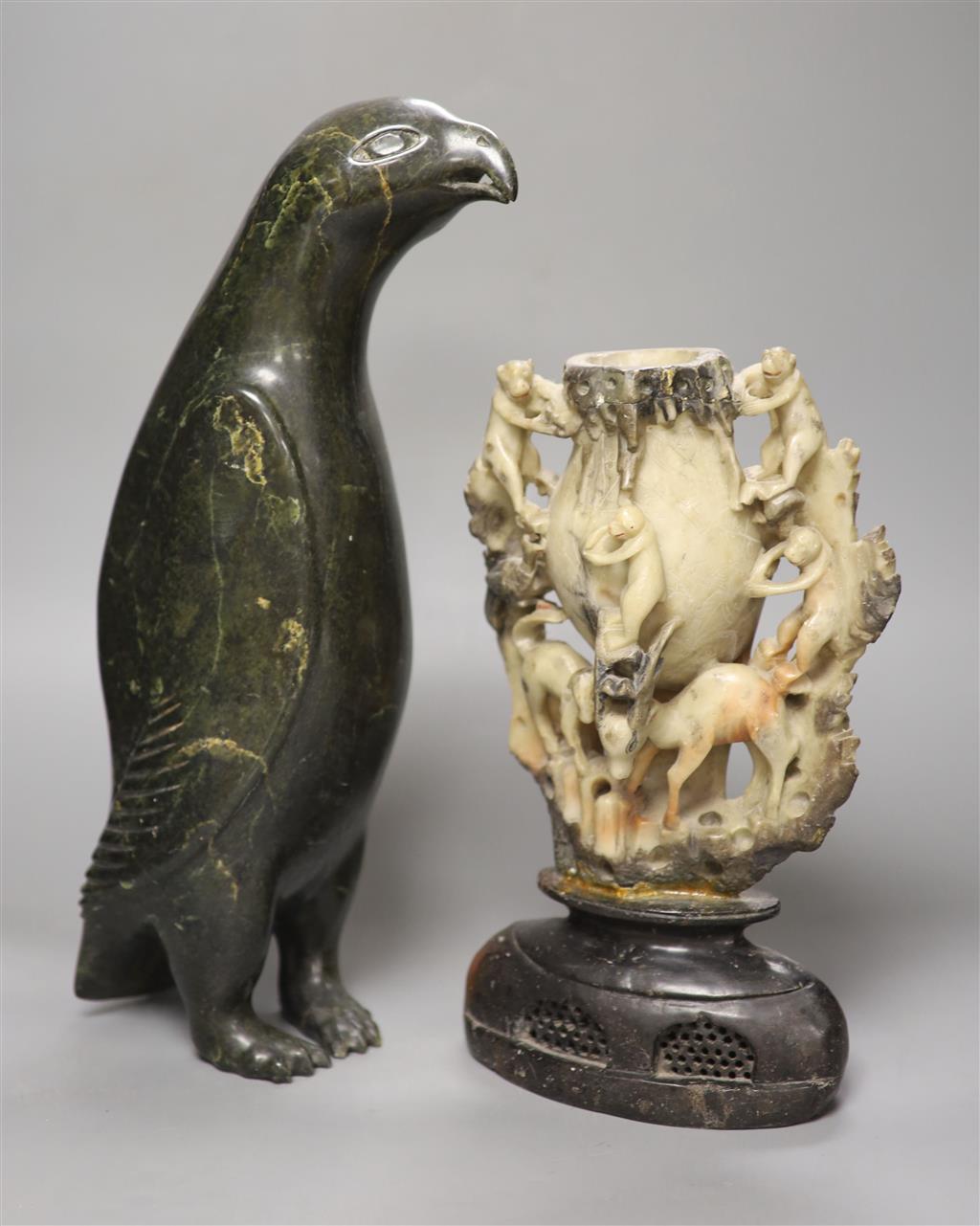 A 19th century Chinese soapstone vase, carved with monkeys, together with an inuit stone carving of a penguin, height 41cm